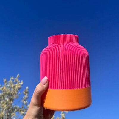 Zweifarbige Vase mit Rillen in Pink und Orange in der Sonne